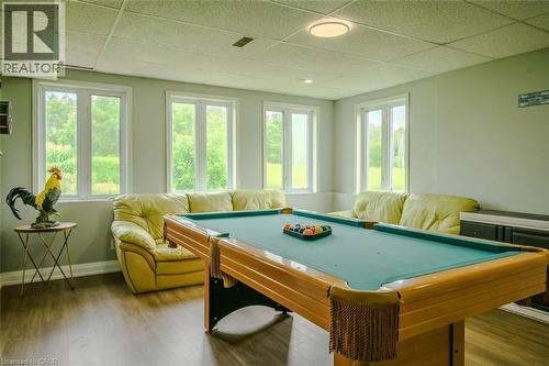 Spacious room featuring wood-finish flooring, multiple windows, a ceiling-mounted light fixture, and a built-in storage unit - 107 6Th Line Line, Haldimand, ON - Indoor Photo Showing Other Room