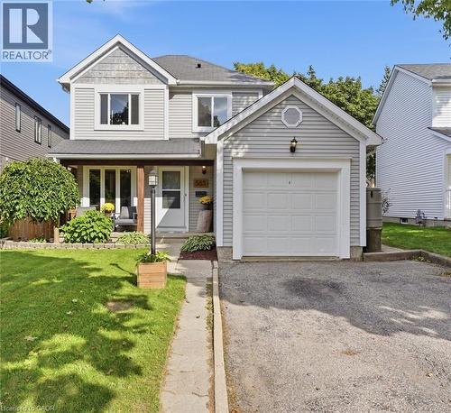 Two-story residence featuring light gray siding, a single-car garage, and a covered front porch with wood-finish support columns - 563 Westvale Drive, Waterloo, ON - Outdoor With Facade