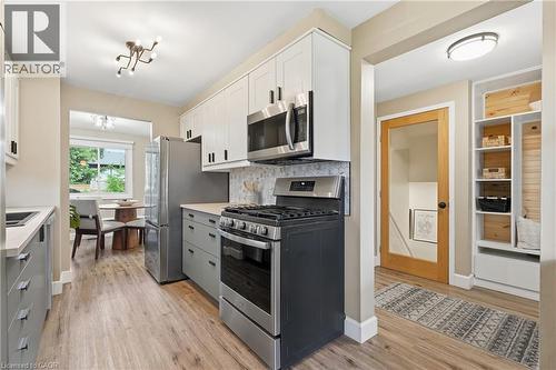 Stainless steel appliances, wood-finish flooring, white upper cabinetry, gray lower cabinetry, and a light-colored countertop - 563 Westvale Drive, Waterloo, ON - Indoor Photo Showing Kitchen With Upgraded Kitchen