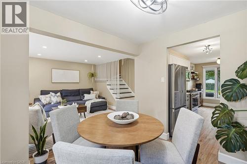 Recessed lighting, wood-finish flooring, staircase with vertical balusters, stainless steel kitchen appliances, and a kitchen window - 563 Westvale Drive, Waterloo, ON - Indoor Photo Showing Dining Room
