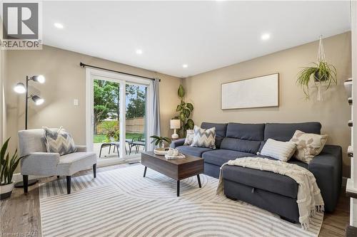 Recessed ceiling lighting, wood-finish flooring, and a sliding glass door providing access to an outdoor patio - 563 Westvale Drive, Waterloo, ON - Indoor Photo Showing Living Room