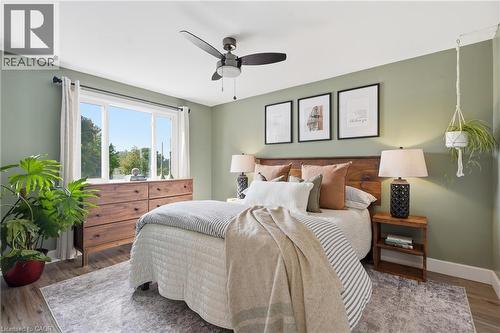 Wood-finish flooring with a multi-pane window and ceiling fan - 563 Westvale Drive, Waterloo, ON - Indoor Photo Showing Bedroom