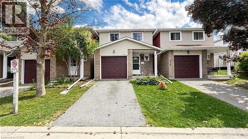 Brick and siding exterior with an integrated garage, a paved driveway, and a covered entry - 304 Bluevale Street N, Waterloo, ON - Outdoor With Facade
