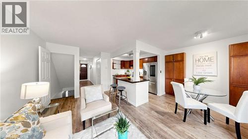 Wood-finish flooring throughout, with a kitchen featuring wood cabinetry, stainless steel appliances, and a breakfast bar - 304 Bluevale Street N, Waterloo, ON - Indoor
