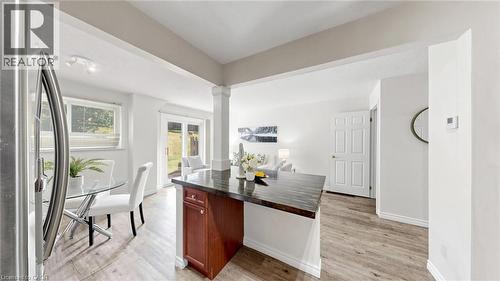 Open-concept living space featuring wood-finish flooring, a kitchen island with storage, and french doors leading to the outdoor area - 304 Bluevale Street N, Waterloo, ON - Indoor