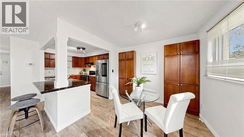 Kitchen featuring wood-finish cabinetry, stainless steel appliances, and dark countertops - 304 Bluevale Street N, Waterloo, ON - Indoor