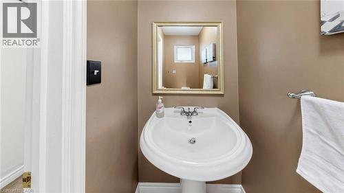 White pedestal sink with chrome faucet, framed mirror, and chrome towel bar - 304 Bluevale Street N, Waterloo, ON - Indoor Photo Showing Bathroom