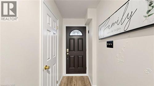 Entryway featuring a dark wood-finish door with an arched glass insert, light wood-finish flooring, and a white paneled interior door with brass hardware - 304 Bluevale Street N, Waterloo, ON - Indoor Photo Showing Other Room