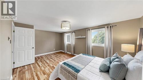 Wood-finish flooring, neutral wall tones, and two windows with natural light - 304 Bluevale Street N, Waterloo, ON - Indoor Photo Showing Bedroom