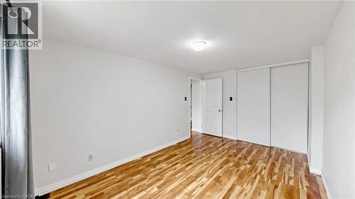 Wood-finish flooring, white walls, white trim, white interior door, and sliding closet doors - 304 Bluevale Street N, Waterloo, ON - Indoor Photo Showing Other Room