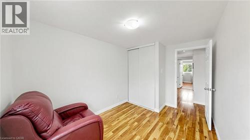 Hardwood flooring, white walls, flush-mount ceiling light, white sliding closet doors, and a white interior door - 304 Bluevale Street N, Waterloo, ON - Indoor Photo Showing Other Room