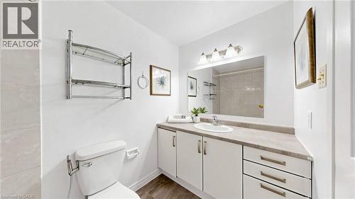 White vanity with integrated sink, rectangular mirror, and three-light fixture - 304 Bluevale Street N, Waterloo, ON - Indoor Photo Showing Bathroom