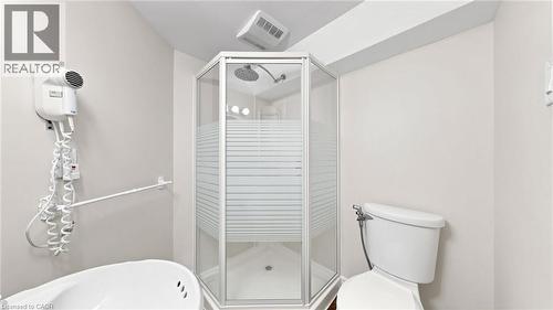 Corner shower stall with frosted glass panels and a white base, adjacent to a white toilet - 304 Bluevale Street N, Waterloo, ON - Indoor Photo Showing Bathroom