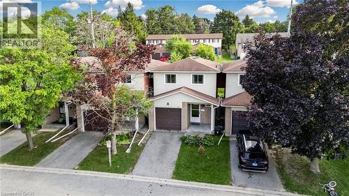 Two-story townhouse with light-colored siding, a brown roof, and a single-car garage - 304 Bluevale Street N, Waterloo, ON - Outdoor