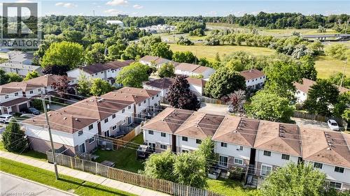 Townhome community with individual fenced yards, brown shingle roofing, and light-colored siding - 304 Bluevale Street N, Waterloo, ON - Outdoor With View