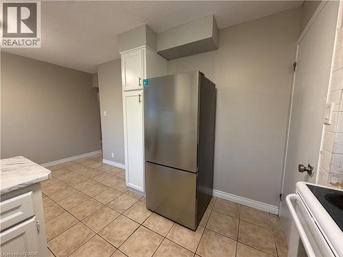 Stainless steel refrigerator, white cabinetry, tile flooring, and a stone-finish countertop - 70 Eagen Drive Unit# Upper Level, Kitchener, ON - Indoor