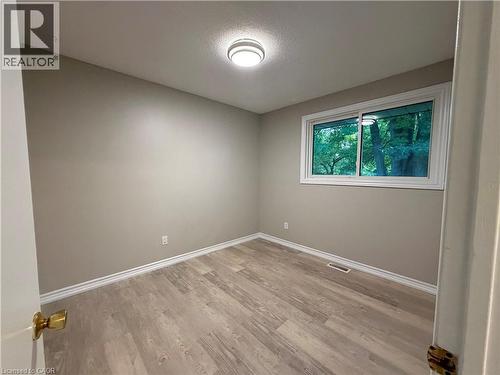 Light gray wall paint, wood-finish flooring, white window trim, and a flush mount ceiling light - 70 Eagen Drive Unit# Upper Level, Kitchener, ON - Indoor Photo Showing Other Room
