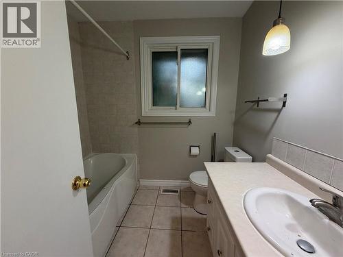 White tile flooring, a white vanity with integrated sink, and a white bathtub with tiled surround - 70 Eagen Drive Unit# Upper Level, Kitchener, ON - Indoor Photo Showing Bathroom