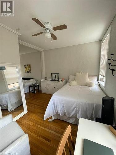 Hardwood flooring throughout, ceiling fan with light fixture, window with blinds, and white walls - 80 E Byron Avenue E Unit# 2, London, ON - Indoor Photo Showing Bedroom