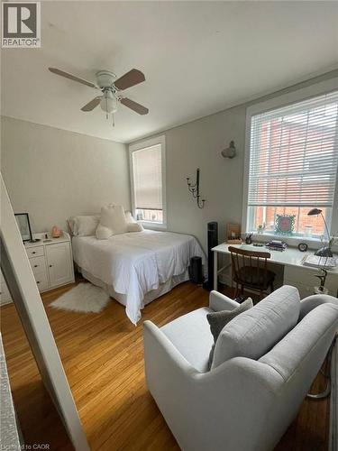 Hardwood flooring throughout, two windows with blinds, a ceiling fan with integrated lighting, and neutral wall tones - 80 E Byron Avenue E Unit# 2, London, ON - Indoor Photo Showing Bedroom