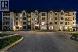 Multilevel building with balconies, illuminated exterior, and prominent entry - 