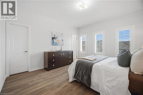 Wood-finish flooring, white walls, and multiple windows with plantation shutters - 20 Todd Crescent, Dundalk, ON - Indoor Photo Showing Bedroom