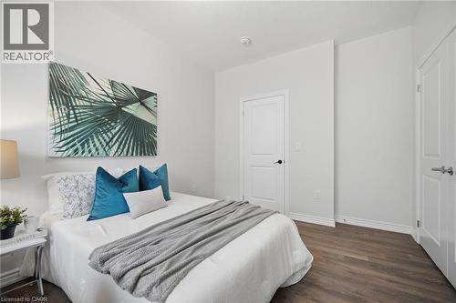 Bright bedroom showcasing warm wood-finish flooring, white painted walls, and clean architectural lines - 20 Todd Crescent, Dundalk, ON - Indoor Photo Showing Bedroom
