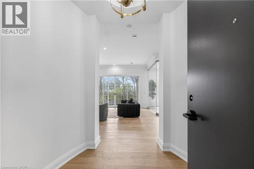 Recessed ceiling lighting, wood-finish flooring, and a contemporary ceiling fixture - 2 Arbourvale Common Unit# 209, St. Catharines, ON - Indoor Photo Showing Other Room