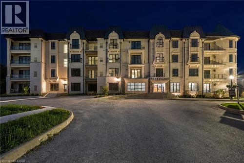 Multilevel building with balconies, illuminated exterior, and prominent entry - 2 Arbourvale Common Unit# 209, St. Catharines, ON - Outdoor With Balcony With Facade