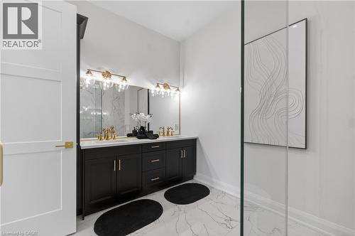 Dual vanity with black cabinetry, brass hardware, and white countertop - 2 Arbourvale Common Unit# 209, St. Catharines, ON - Indoor Photo Showing Bathroom