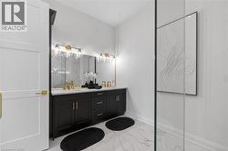Dual vanity with black cabinetry, brass hardware, and white countertop - 