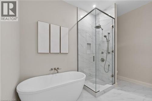 Freestanding soaking tub with wall-mounted fixtures - 2 Arbourvale Common Unit# 209, St. Catharines, ON - Indoor Photo Showing Bathroom