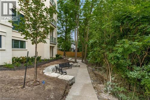 Exterior building with light-colored siding, multiple windows, and balconies with glass railings - 2 Arbourvale Common Unit# 209, St. Catharines, ON - Outdoor