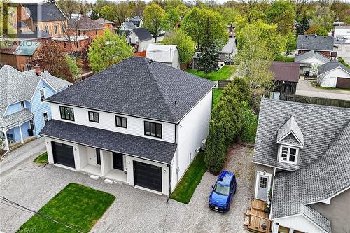Modern duplex featuring white siding, black-framed windows, and two single-car garages with black doors - 45B Howard Street, Hagersville, ON 