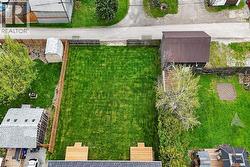 Expansive fenced yard featuring a manicured lawn, two distinct wood decks, and mature perimeter trees - 