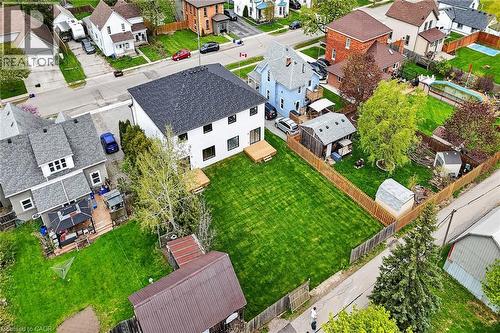 Expansive backyard featuring a manicured lawn, mature trees, a wood privacy fence, and finished deck - 45B Howard Street, Hagersville, ON 