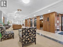 Carpeted flooring, recessed lighting, drop ceiling, elevator access, and wood paneling - 
