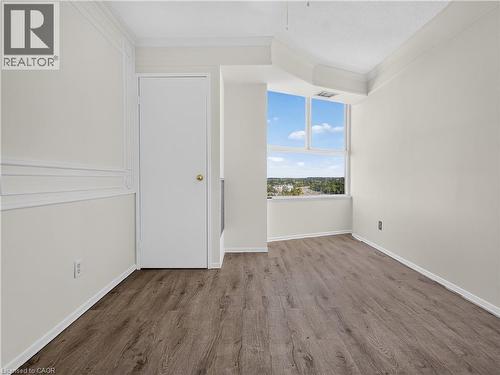 Wood-finish flooring, white walls, decorative wall molding, crown molding, and large windows - 7 Gale Crescent Unit# 1107, St. Catharines, ON 