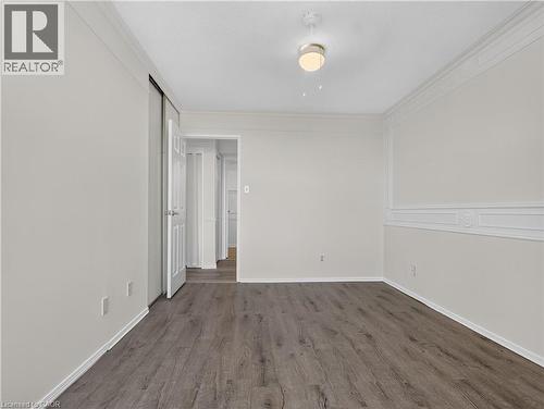 Wood-finish flooring, white paneled walls, ceiling fan with light fixture, and white trim throughout - 7 Gale Crescent Unit# 1107, St. Catharines, ON 