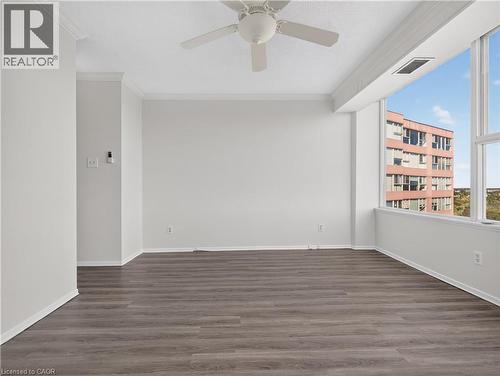 Expansive window wall, wood-finish flooring, ceiling fan, crown molding, and bright white walls - 7 Gale Crescent Unit# 1107, St. Catharines, ON 