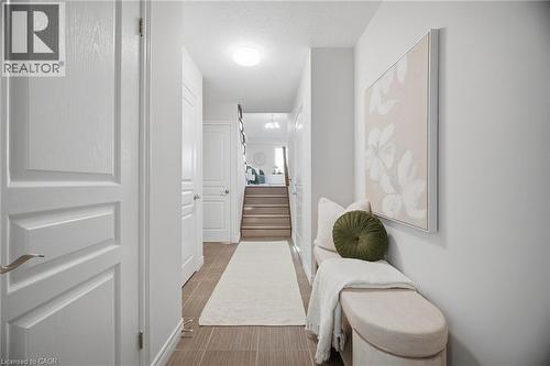 Tiled flooring, white paneled doors, light neutral wall color, and a staircase with wood-finish treads - 98 Bloom Crescent, Stoney Creek, ON 
