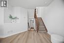 Wood-finish flooring throughout, solid wood staircase with wood handrail, and crisp white wall finishes - 98 Bloom Crescent, Stoney Creek, ON 