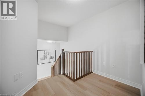Wood-finish flooring with white baseboards - 98 Bloom Crescent, Stoney Creek, ON 