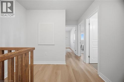 Wood-finish flooring, white walls, and a wooden railing - 98 Bloom Crescent, Stoney Creek, ON 
