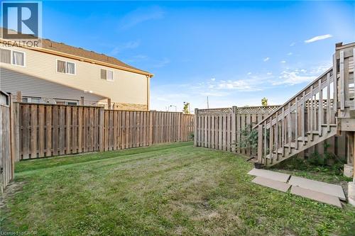 Fenced backyard with wood privacy fencing, a wood deck, and wood stairs - 98 Bloom Crescent, Stoney Creek, ON 