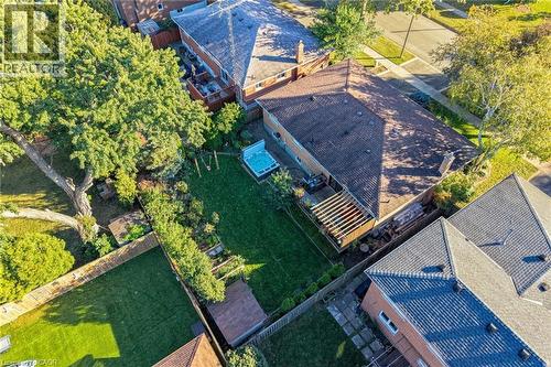 Expansive backyard with a manicured lawn, established trees, and a wooden pergola - 1060 Dowland Crescent, Burlington, ON 