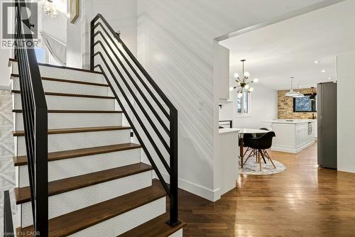 Hardwood flooring, metal railing, mosaic tile stair risers, built-in kitchen island, brick accent wall - 9 Midway Street, Hamilton, ON 