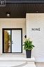 White brick exterior with black trim, modern front door, black soffit, and concrete steps - 9 Midway Street, Hamilton, ON 