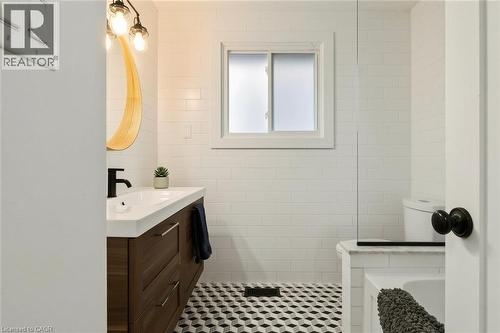 Wood-finish vanity with an integrated sink and matte black faucet - 9 Midway Street, Hamilton, ON 