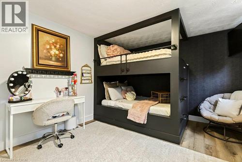Built-in bunk beds with integrated access, light-colored wall paint, textured dark wall covering, and wood-finish flooring - 9 Midway Street, Hamilton, ON 